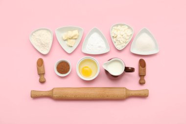 Pembe arka planda tatlı tarçınlı rulo hazırlamak için farklı malzemeler