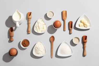 Gri arka planda tatlı tarçın rulosu hazırlamak için farklı malzemeler