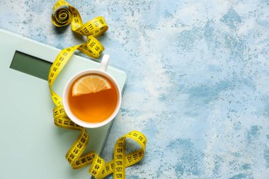 Bir fincan diyet çayı, mezura ve renk arkaplanındaki pullar. Kilo verme konsepti