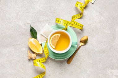 Bir fincan diyet çay, limon ve arka planda mezura. Kilo verme konsepti