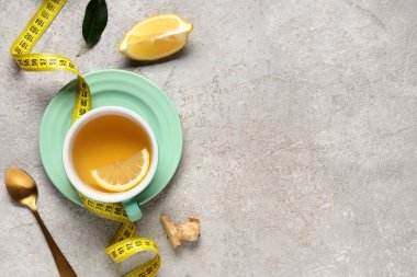Bir fincan diyet çay, limon ve arka planda mezura ile kompozisyon. Kilo verme konsepti