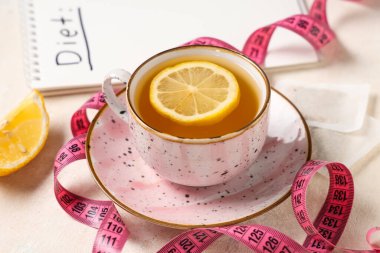 Kilo vermek ve beyaz grunge masasında şerit çekmek için bir fincan çay.