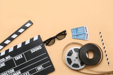 Sinema biletleri, gözlükler ve bej arka planda film makaraları olan alkışlar.