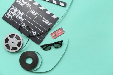 Film makaralı film alkışları, sinema bileti ve turkuaz arka planda gözlük.