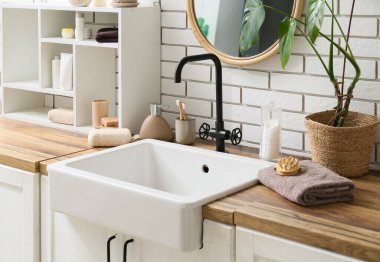 Banyo malzemeleri, raf ve lavabo banyodaki beyaz tuğla duvarın yanında.