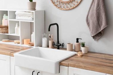 Lavabo, banyo aksesuarları ve banyodaki ışık duvarının yanındaki raf.