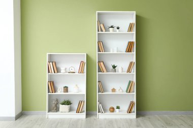 Odadaki yeşil duvarın yanındaki kitap rafları