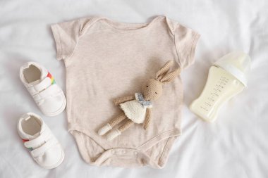 Bebek sütü formülü, oyuncak tavşan, tulum ve patik.