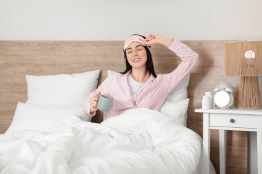 Evinde bir fincan taze kahveyle güzel genç bir bayanın sabahını.