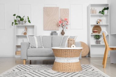 İçinde kanepe, masa ve vazoda manolya çiçekleri olan bir oturma odası.