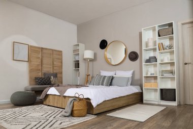 Ayna, şapka ve raf üniteleriyle şık bir yatak odası.