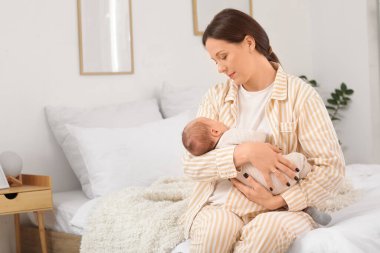 Annenin kucağında uyuyan tatlı bir bebek var.