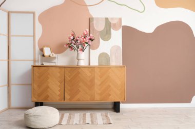 İçinde resim, kitap, dekor ve manolya çiçekleri olan çekmeceler.