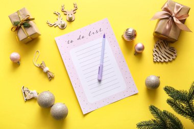 Sarı zemin üzerinde hediyeler ve Noel dekoru olan boş yapılacaklar listesi