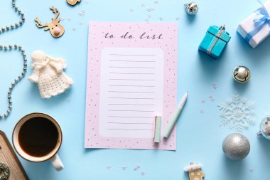 Kahve fincanı ve mavi arka planda Noel dekoru olan boş yapılacaklar listesi