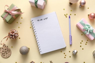 Hediyeler ve bej arka planda Noel dekoru olan boş yapılacaklar listesi