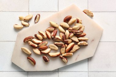 Beyaz fayanslı lezzetli Brezilya fındıkları olan tahta