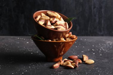 Siyah arka planda lezzetli Brezilya fındıkları olan kaseler.