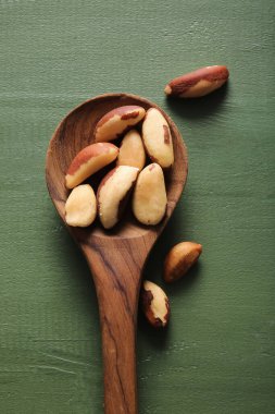 Lezzetli Brezilya cevizli kaşık yeşil ahşap arka plan