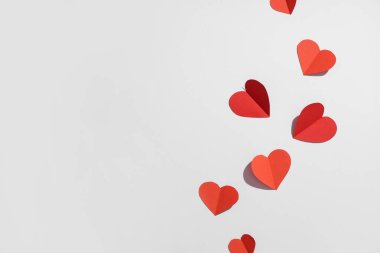 Gri arka planda kırmızı kağıt kalpler. Sevgililer Günü kutlaması