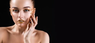 Siyah arka planda altın makyajlı güzel bir genç kadın.