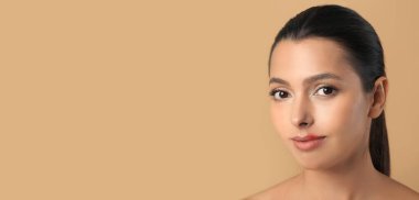 Bej arkaplan üzerinde uçuk olan genç ve güzel bir kadın.