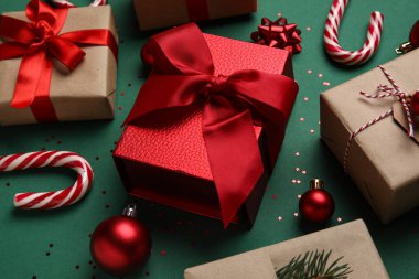 Noel baloları hediye kutuları ve yeşil arka planda şeker kamışları.