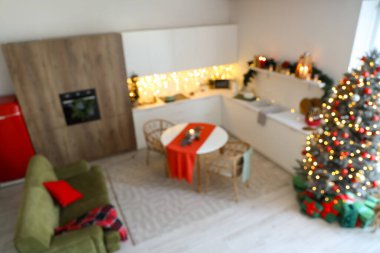 Tezgahları, yemek masası ve Noel ağacı olan bulanık mutfak manzarası