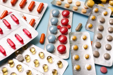 Mavi arka planda farklı haplar içeren kabarcık paketleri