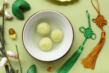 Bir kase tangyuan, Çin dekoru ve yeşil arka planda sakura. Dongzhi Festivali