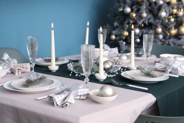 Yemek odasında yanan mumlar ve Noel süslemeleri olan güzel bir masa, yakın plan.