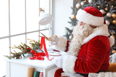 Noel Baba evde Noel hediyesi yapıyor.