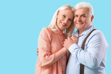 Mavi arka planda mutlu olgun bir çift