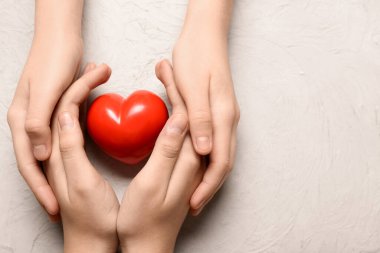 Beyaz arka planda kırmızı kalpli kadın ve çocuğun elleri