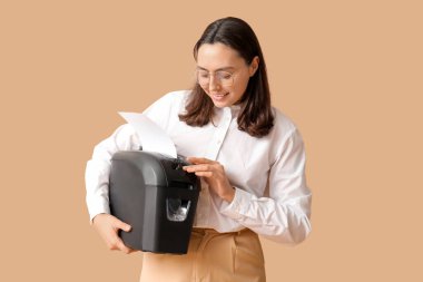 Bej arkaplanda kağıt öğütücüsü olan sekreter