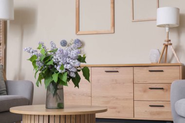 Oturma odasının iç tarafındaki masada cam vazoda duran güzel bir buket çiçek.