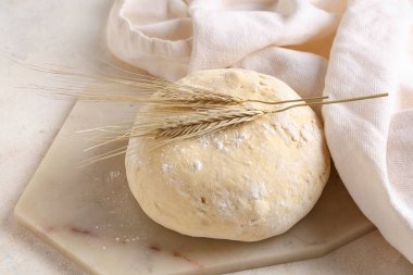 Beyaz zemin üzerinde taze hamur ve buğday bulunan tahta