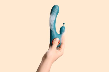 Bej arka planda vibratör yıkayan kadın, yakın plan.