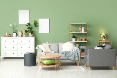 Gri kanepesi, rahat koltuğu, yumuşak yastıkları ve kahve masası olan şık bir oturma odası.