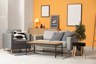 Oturma odasının iç tarafında rahat bir kanepe, koltuk ve sehpa.