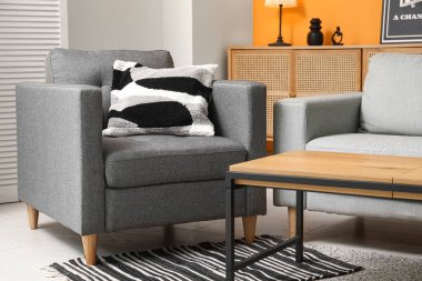 Oturma odasının iç tarafında rahat bir kanepe, koltuk ve sehpa.