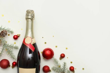 Noel toplu bir şişe şampanya, köknar dalları ve beyaz arka planda konfeti.