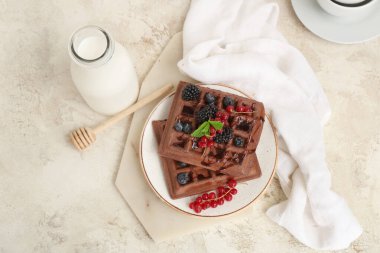 Beyaz arka planda taze böğürtlen ve bir şişe sütle Belçika usulü tatlı waffle.