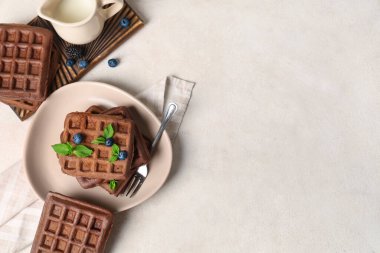 Beyaz arka planda taze yaban mersinli Belçika waffle 'ı, nane ve bir sürahi süt.