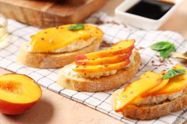 Şeftalili bruschetta, bej arka planda keten tohumu ve fesleğen, yakın plan.