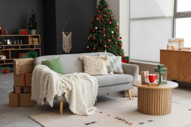 Koltuk, içkili kahve masası, fener ve oturma odasının içindeki Noel ağaçları.
