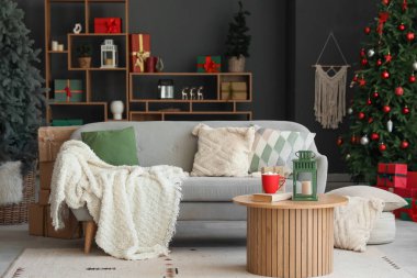Koltuk, içkili kahve masası, fener ve oturma odasının içindeki Noel ağaçları.