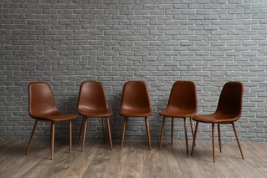 Gri tuğla duvarın yanında şık sandalyeler