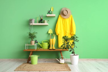 Atölyenin içinde bank, bahçe aletleri ve bitkiler var.