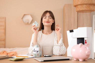 Parası olan kız öğrenci masada şans diliyor. Eğitim tasarruf kavramı